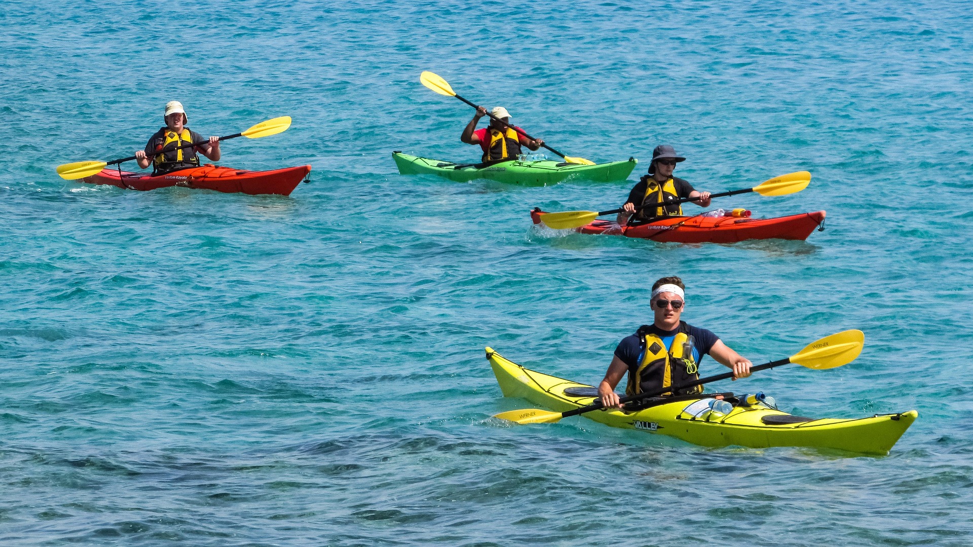 A group of kayakers paddling on the calm, blue waters of Lake Union in Seattle, enjoying a sunny day and the vibrant outdoor activities near Seattle.