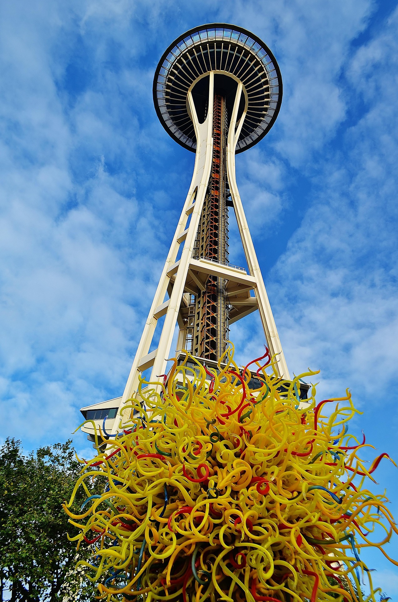 The iconic Space Needle with vibrant Chihuly Glass sculptures in the foreground, showcasing two must-see attractions in Seattle.